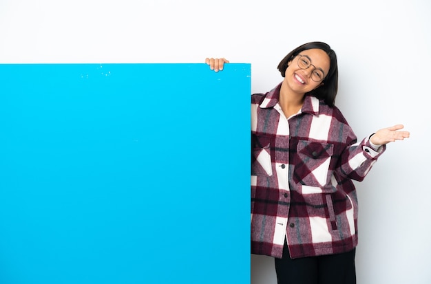 Jonge gemengde rasvrouw met een groot blauw aanplakbiljet dat op witte achtergrond wordt geïsoleerd die en uitnodigt om met hand te komen