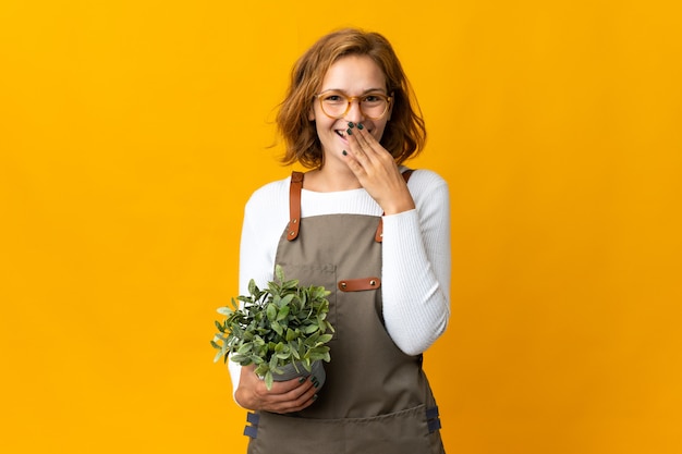 Jonge Georgische vrouw die een geïsoleerde plant houdt