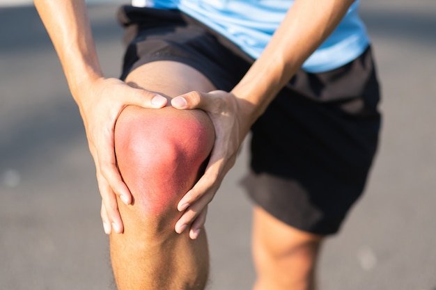 Jonge geschiktheidsmens die zijn verwonding van het sportenbeen houden. spierpijn tijdens training