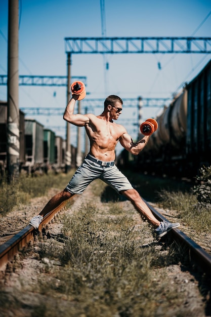 Jonge gespierde man gaat sporten op straat Jonge sterke sportman training