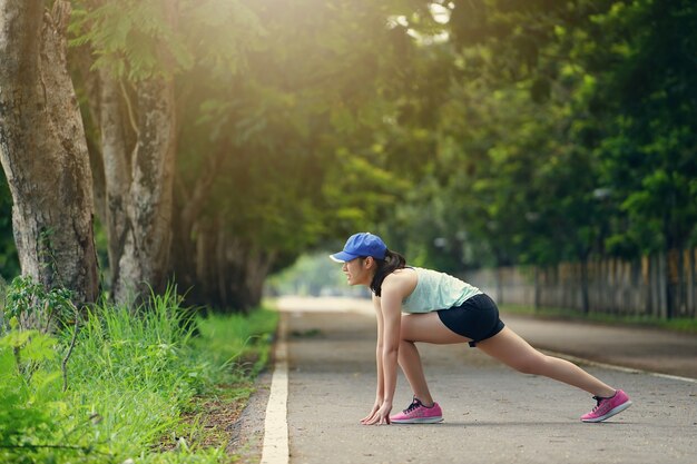 Jonge gezonde fitness vrouw loper uitrekkende benen