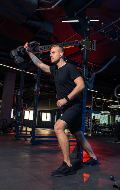 Jonge gezonde man doet oefeningen in de sportschool knappe sterke man traint hard in de sportschool