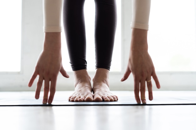 Jonge glimlachende aantrekkelijke vrouw die yoga beoefent