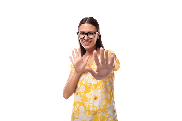 Foto jonge glimlachende brunette vrouw met een bril die een zomer oranje t-shirt draagt