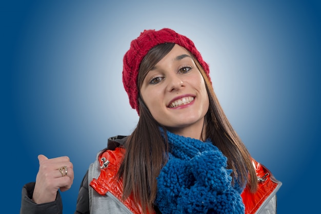 Jonge glimlachende donkerbruine vrouw met de rode winter GLB