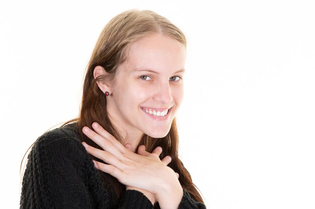 Jonge glimlachende vrouw die gelukkig kijkt op een witte achtergrond grote glimlach op een schattig gezicht dat er mooi en mooi uitziet met handen die de nek raken