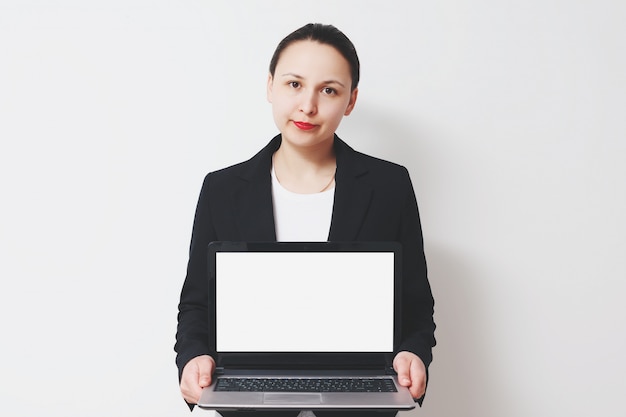 Jonge glimlachende vrouw die laptop houdt