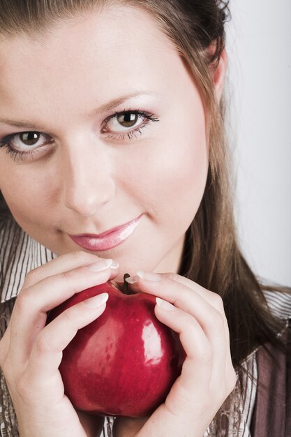 Jonge glimlachende vrouw met rode appel.