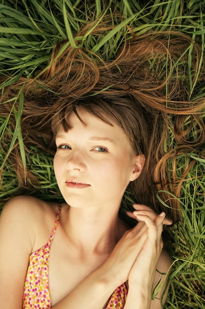 Jonge glimlachende vrouw op het gras