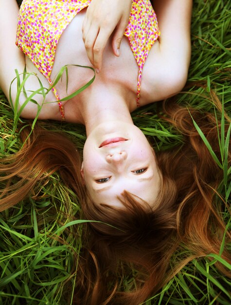 Jonge glimlachende vrouw op het gras