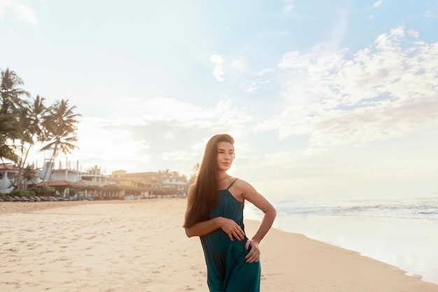 Jonge glimlachende vrouw op het strand Portret van mooi meisje met oceaan op achtergrond