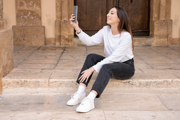 Foto jonge glimlachende vrouw van de millenniumgeneratie die selfie maakt