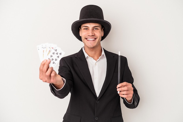 Jonge goochelaar blanke man met een magische kaarten en een toverstokje geïsoleerd op een witte achtergrond