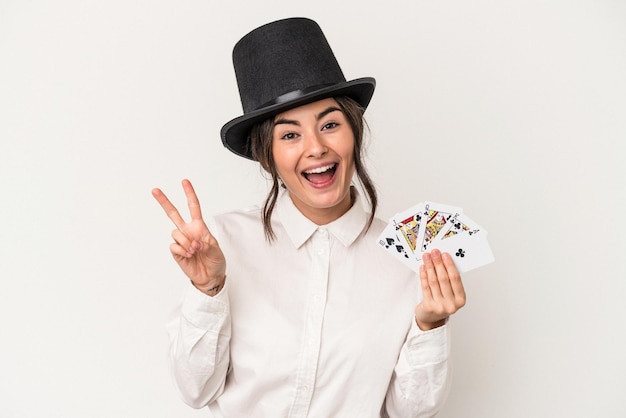 Jonge goochelaar vrouw met een toverstokje geïsoleerd op een witte achtergrond blij en zorgeloos met een vredessymbool met vingers