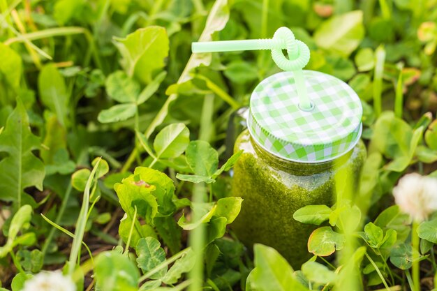 Jonge grappige man houdt detox smoothie met rietje. Concept van gezonde levensstijl, mensen en voedsel.