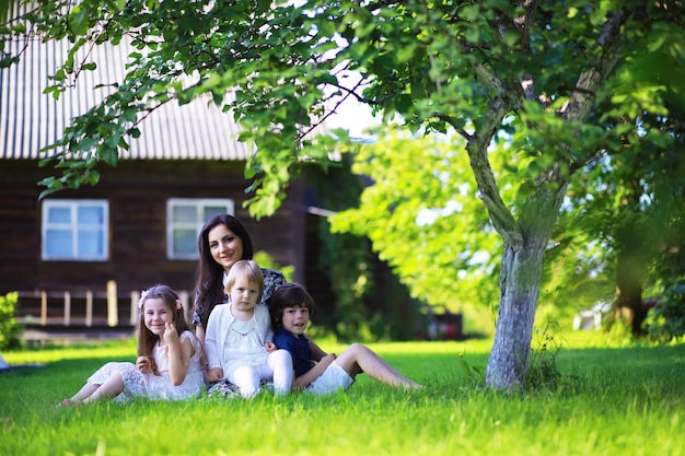 Jonge grote familie op een zomerse ochtendwandeling. Mooie moeder met kinderen speelt in het park.