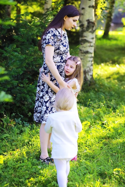 Jonge grote familie op een zomerse ochtendwandeling. Mooie moeder met kinderen speelt in het park.