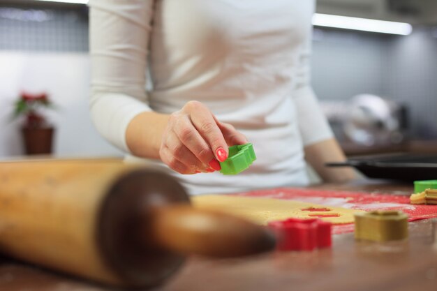 Jonge handen die gemberdeeg snijden bij moderne keuken