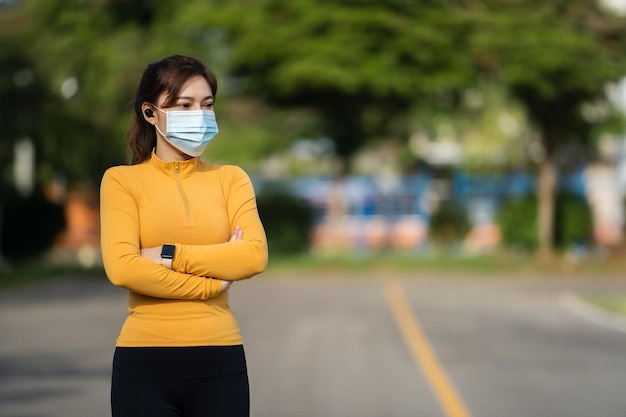 Jonge hardlopervrouw met medisch masker om de pandemie van CoronavirusCovid19 te beschermen