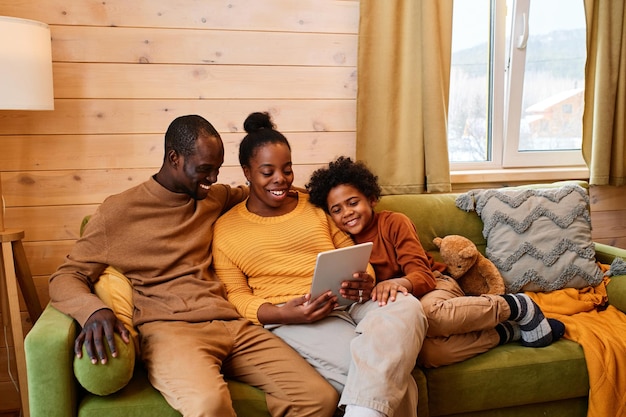 Jonge hedendaagse familie communiceren in videochat in hun landhuis