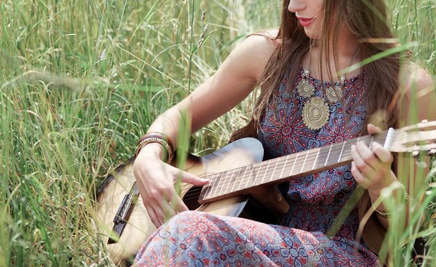 Jonge hippievrouw met gitaar zingt een lied