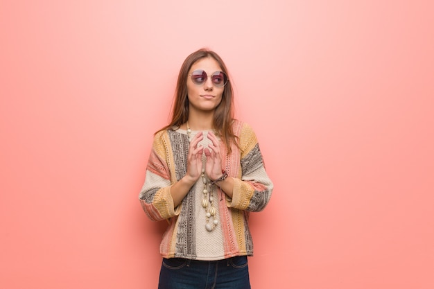 Jonge hippievrouw op roze die een plan bedenkt