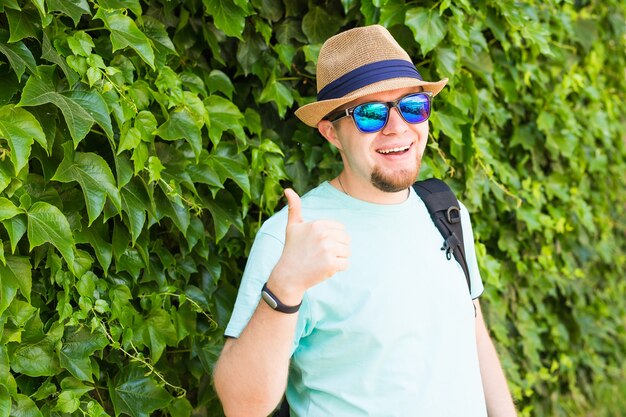 Jonge hipster man met duim omhoog in park