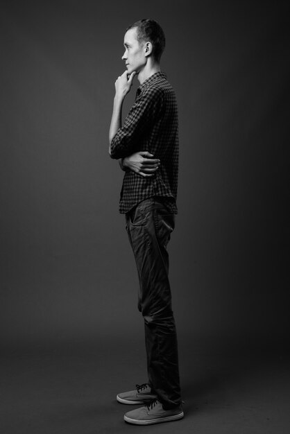 jonge hipster man tegen grijze muur in zwart-wit
