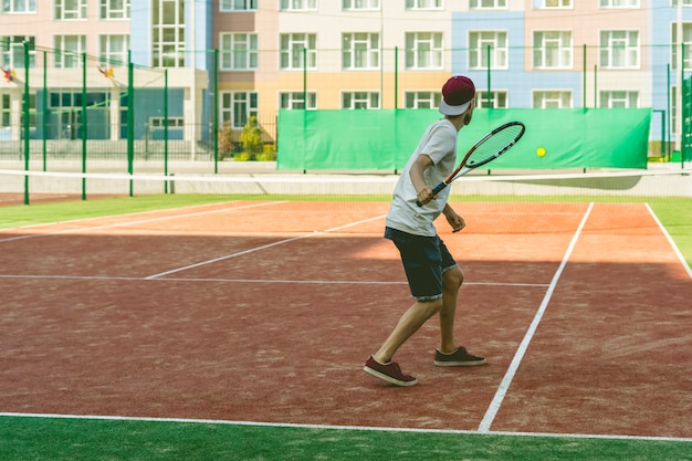 Jonge hipster op het hof. de casual tennisser