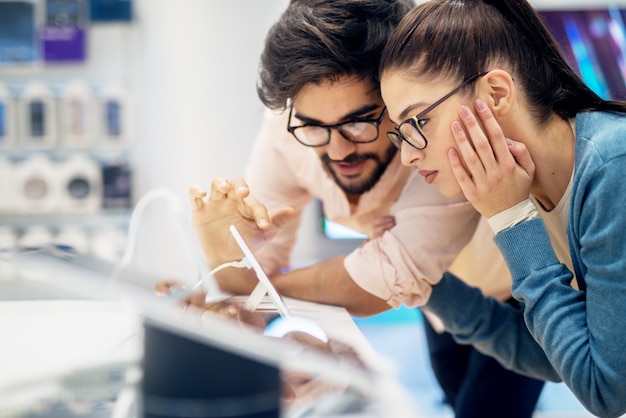 Jonge hipster stijlvolle glimlachend multiraciale paar testen van de nieuwe telefoon