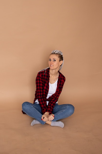 Foto jonge hipster vrouw met dreadlocks geïsoleerd op beige muur