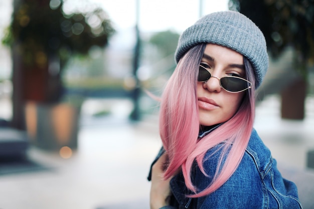 Jonge hipster vrouw met roze haren en hoed