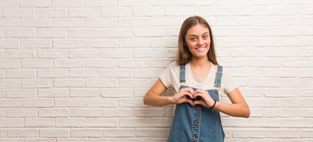 Jonge hipstervrouw die een hartvorm met handen doet