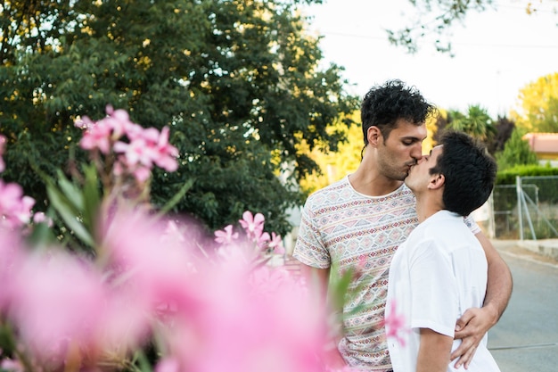 Jonge homo paar verliefd zoenen in de natuur Twee jonge geliefden buitenshuis Gelukkig Kaukasisch paar