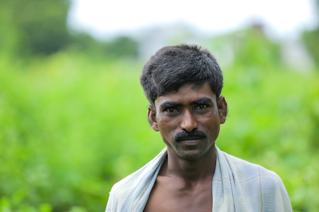 Jonge Indiase arme man permanent over natuur achtergrond