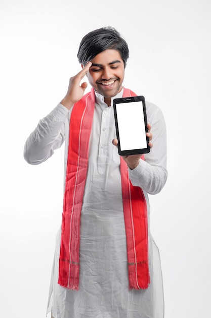 Jonge Indiase boer die slimme telefoon of tablet toont en uitdrukking geeft op witte achtergrond