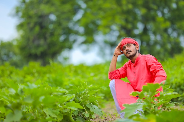 Jonge Indiase boer in stress of denken op auberginegebied