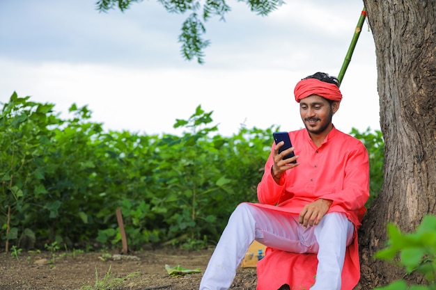 Jonge Indiase boer met behulp van de telefoon