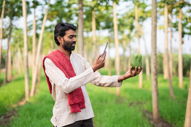 Jonge Indiase boer met behulp van een slimme telefoon