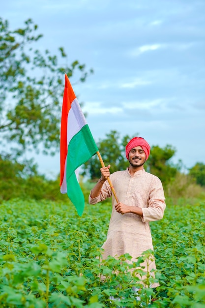 Jonge Indiase boer met Indiase vlag op landbouwveld