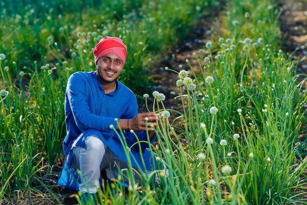 Jonge Indiase boer op het gebied van de landbouw van de ui