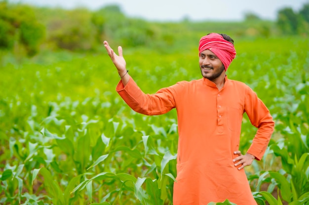 Jonge Indiase boer op maïsveld.