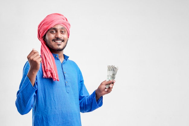 Jonge Indiase boer poseren met valuta op witte achtergrond.