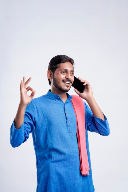 Jonge Indiase boer praten op mobiele telefoon op witte achtergrond.