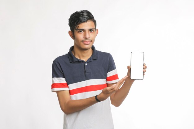 Jonge Indiase college student smartphone scherm tonen op witte achtergrond.