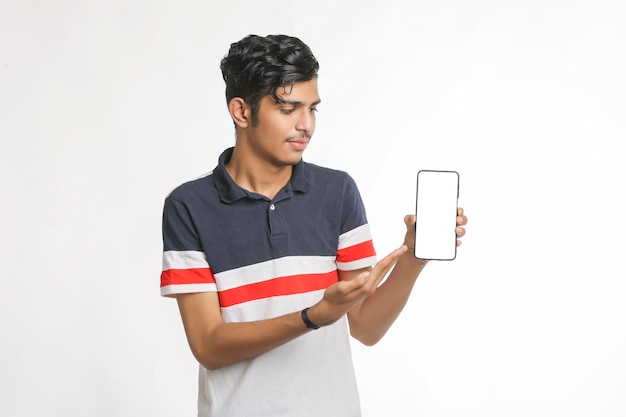 Jonge Indiase college student smartphone scherm tonen op witte achtergrond.