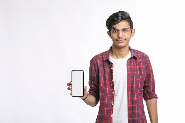 Jonge Indiase college student smartphone scherm tonen op witte achtergrond.