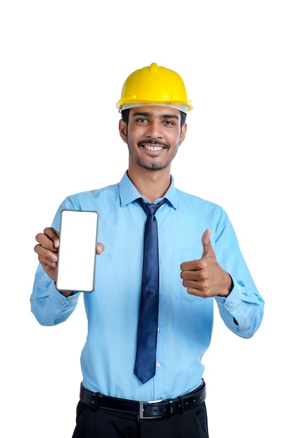 Jonge Indiase ingenieur of bouwvakker die het scherm van de smartphone toont.