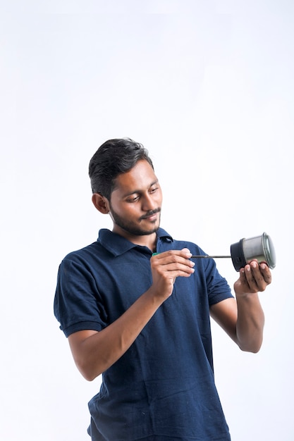 Jonge Indiase man die elektronica-keukengerei repareert met gereedschap in de hand