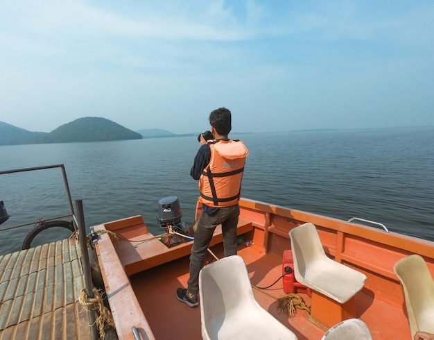 Jonge indiase man die foto's maakt vanaf de boot